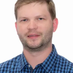 Portret mężczyzny w niebieskiej koszuli w kratę na białym tle.