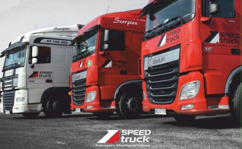 Trzy ciężarówki DAF w kolorach białym i czerwonym, ustawione w rzędzie, z logo firmy Speed Truck na boku kabiny i napisem Scorpion na dachu.