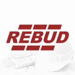 Logo firmy REBUD w kolorze bordowym, umieszczone nad zwiniętymi planami budowlanymi i białym kaskiem ochronnym na jasnym tle.