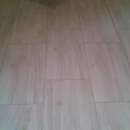 Ułożona podłoga z płytek imitujących drewno, widok z góry, szare fugi.