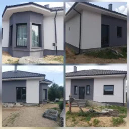 Nowoczesny dom po renowacji elewacji, z szarymi i białymi ścianami, czarną stolarką okienną i grafitowym dachem. Widoczne elementy wykończeniowe.