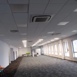Sufit podwieszany z wbudowanym oświetleniem i systemem klimatyzacji w przestronnym biurze w Krotoszynie.