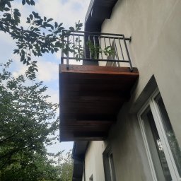 Balkon ze stali czarnej lakierowanej proszkowo obudowany deskami z modrzew syberyjski.