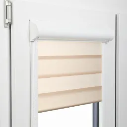 Fragment białego okna PCV z zamontowaną roletą dzień noc w odcieniach beżu, widoczne poziome pasy tkaniny.