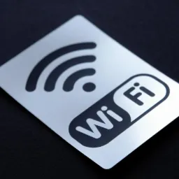 Metalowa wizytówka z symbolem Wi-Fi i napisem 'Wi Fi' na czarnym tle, wykonana w Zabrzu.