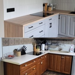 Arpex glasswood - Porównanie: Jasnoszara kuchnia z drewnianym blatem i czarnymi uchwytami vs. ciemnobrązowa kuchnia z białym blatem i ceramicznymi uchwytami. Dwa różne style.