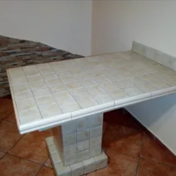 Wykonana na zamówienie, podwieszana, kafelkowana półka/blat z kwadratową podstawą, dopasowana kolorystycznie do podłogi i dekoracyjnej ściany z płytek imitujących kamień.