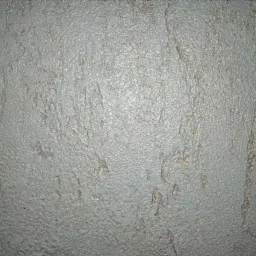 Szara ściana z wyraźną, nieregularną fakturą, przypominającą efekt dekoracyjnego tynku.