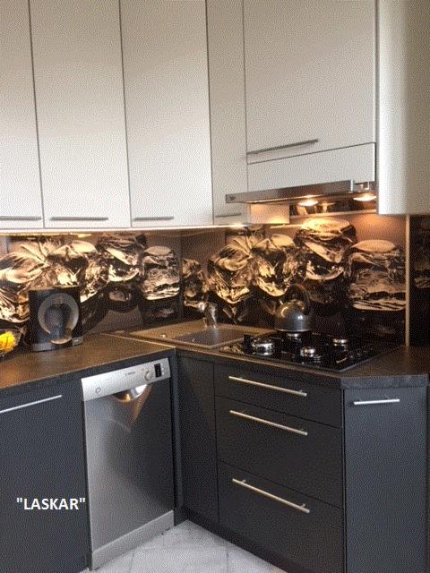 Nowoczesna kuchnia z szarymi dolnymi szafkami i białymi górnymi, czarny blat i fototapeta z motywem górskim nad blatem.