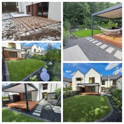 Nowoczesny ogród z drewnianym tarasem, pergolą, ścieżką z płyt i grysu, oświetleniem dekoracyjnym i równo przystrzyżonym trawnikiem przy białym domu.