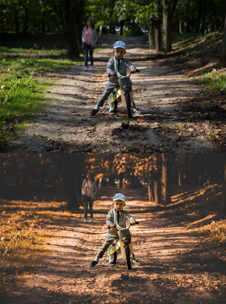 Chłopiec na drewnianym rowerku biegowym w lesie, mama w tle na ścieżce.