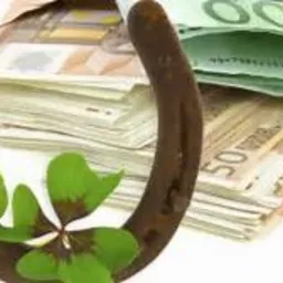 Podkowa z czterolistną koniczyną na tle stosu banknotów euro w kopercie, symbolizująca szczęście w finansach.