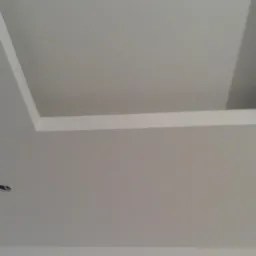 Wykończony sufit z wnęką oświetleniową w kształcie prostokąta, z widocznym otworem na punktowe oświetlenie w dolnej części kadru.