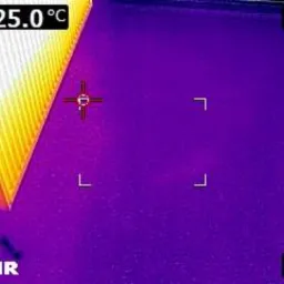 Termowizyjne zdjęcie grzejnika i podłogi, z wyraźnie zaznaczonym rozkładem temperatur w pomieszczeniu, wskazującym na potencjalne straty ciepła.