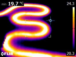 Termowizyjne zdjęcie rury grzewczej, gradient temperatury od fioletu do żółci, wskazujący na rozkład ciepła.