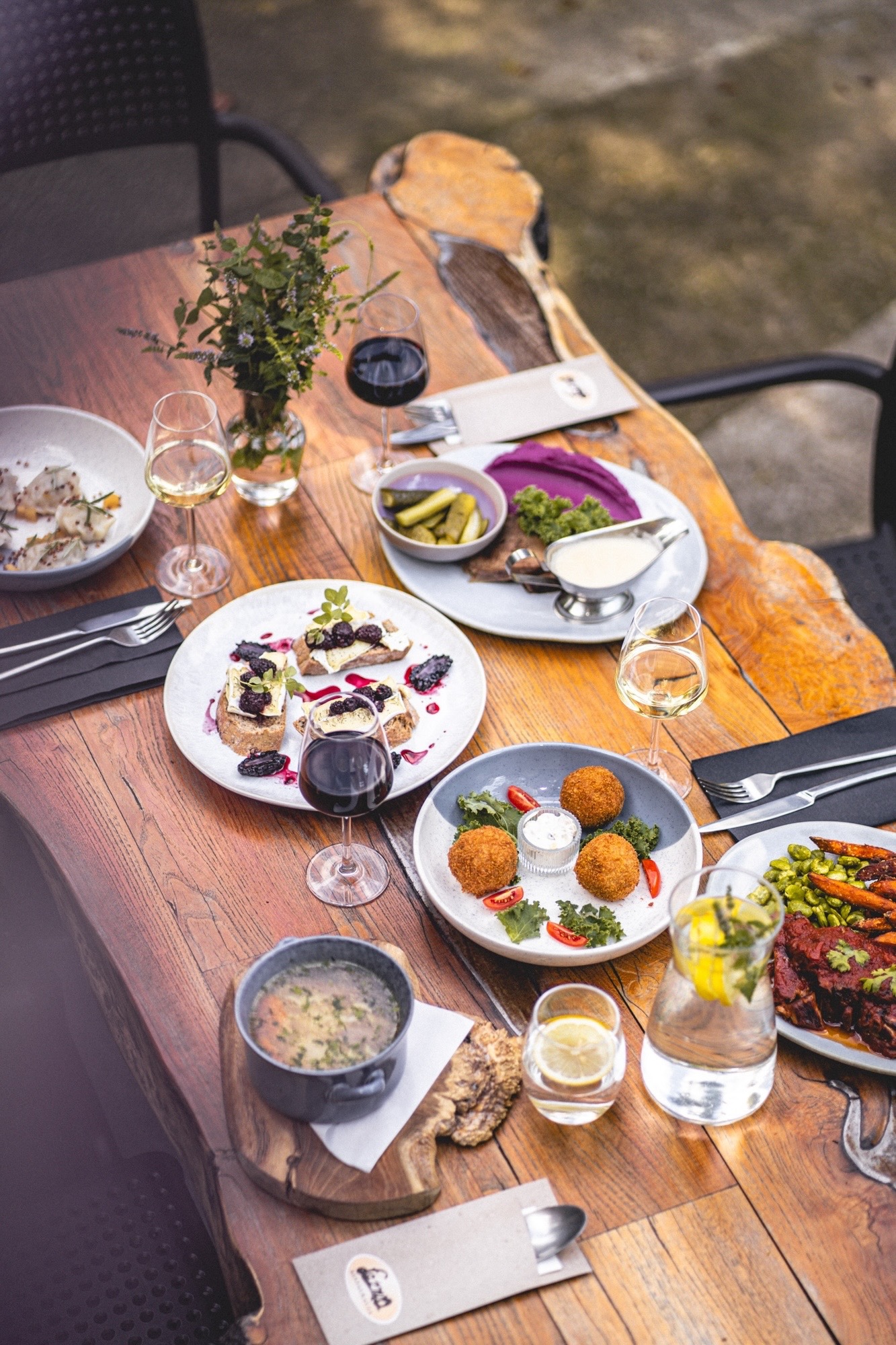 Bogato zastawiony stół z drewna z różnorodnymi daniami, napojami i dekoracjami. Elegancki catering na przyjęciu, widok z góry.