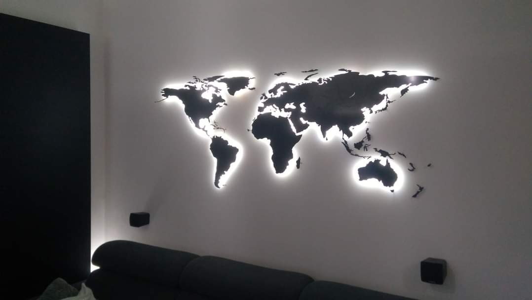 Podświetlana mapa świata zamontowana na ścianie w Czerwonaku, widoczna część sofy w dolnej części kadru.