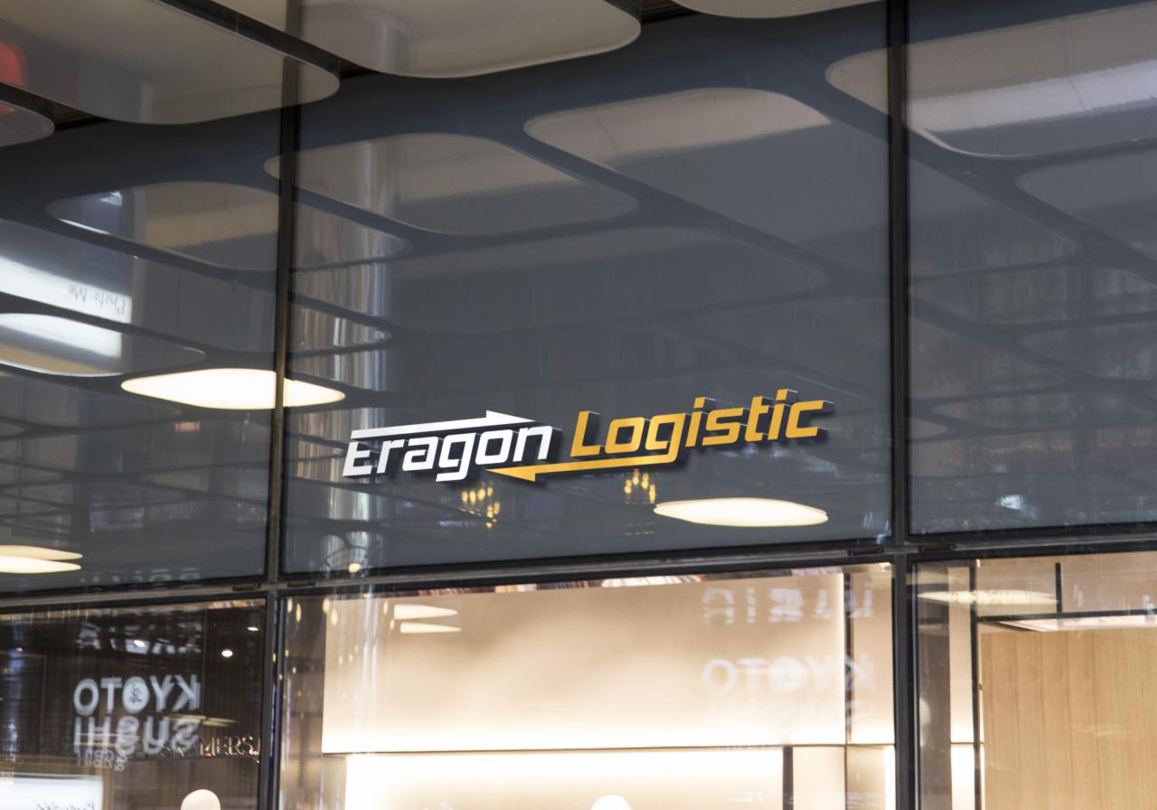 Logo firmy Eragon Logistic na szklanej fasadzie budynku z widocznymi odbiciami wnętrza i oświetlenia.
