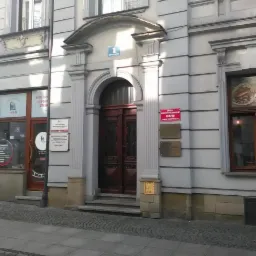 Fasada kamienicy z szyldami: Kancelaria Prawna, Zarząd Oddziału Rejonowego oraz Atelier. Nad wejściem numer budynku: 1, ul. Szwedzka.