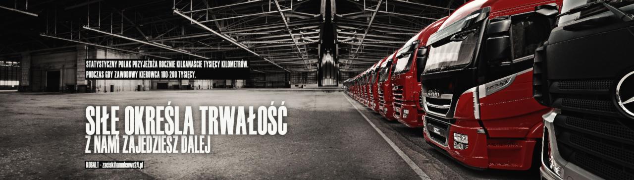 Rząd czerwonych ciężarówek IVECO i czarna ciężarówka Mercedes-Benz w hali przemysłowej, z widocznym hasłem reklamowym i nazwą firmy KOBALT