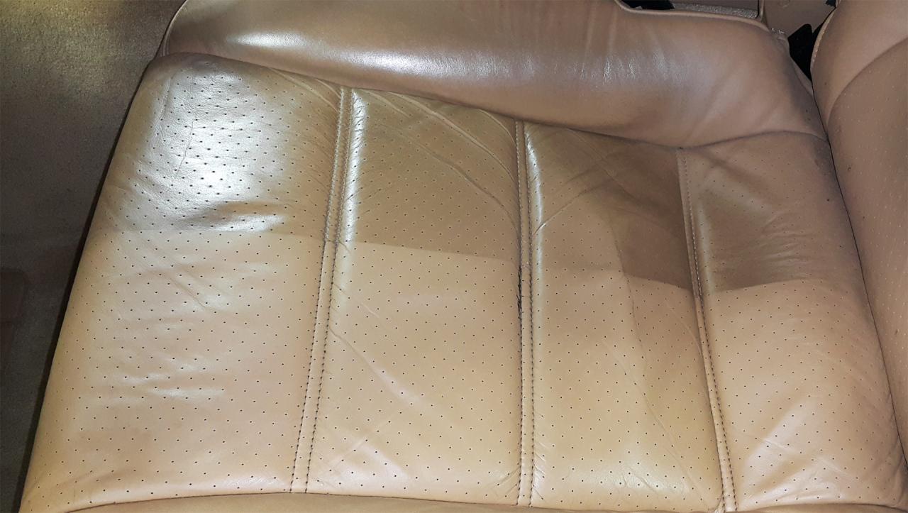 Beżowe skórzane siedzenie samochodowe z perforacją, częściowo wyczyszczone, ukazujące różnicę w odcieniu i fakturze przed i po czyszczeniu.