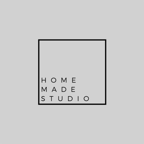 Minimalistyczne logo 'Home Made Studio' w czarnej ramce na szarym tle.