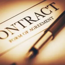 Umowa prawna leżąca na stole, obok niej pióro wieczne, ciepłe oświetlenie.