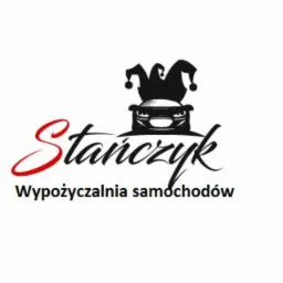 Logo firmy z nazwą 'Stańczyk', stylizowaną czcionką, pod którą widnieje napis 'Wypożyczalnia samochodów', a nad nią grafika samochodu z nałożoną czapką błazna.