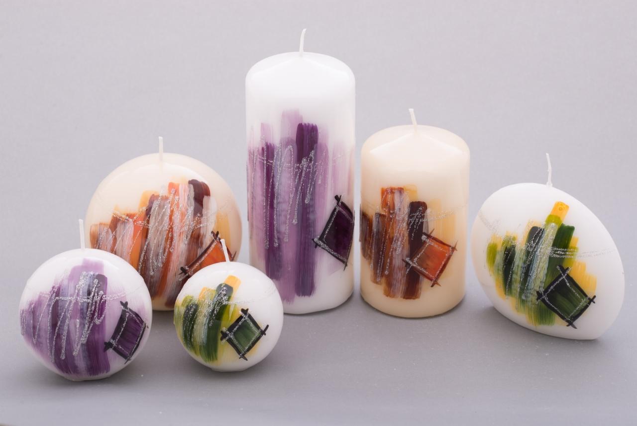 Zestaw dekoracyjnych świec o różnych kształtach i kolorach, zdobionych abstrakcyjnymi wzorami z akcentami brokatu, na neutralnym tle.