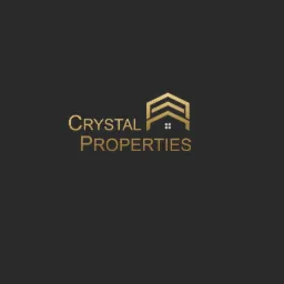 Złote logo firmy Crystal Properties na ciemnoszarym tle, przedstawiające stylizowany dom z trzema dachami w formie strzałek.