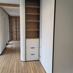 TKACH MONTAGE SERVICE Sergii Tkach - Nowoczesne wykończenie wnętrza: drewniana podłoga, zabudowa z półkami i szufladami, biała ściana z dekoracyjnymi panelami. Minimalistyczny design.