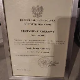 Oprawiony w srebrną ramkę Certyfikat Księgowego wydany przez Ministra Finansów Rzeczypospolitej Polskiej, z pieczęcią i podpisem.
