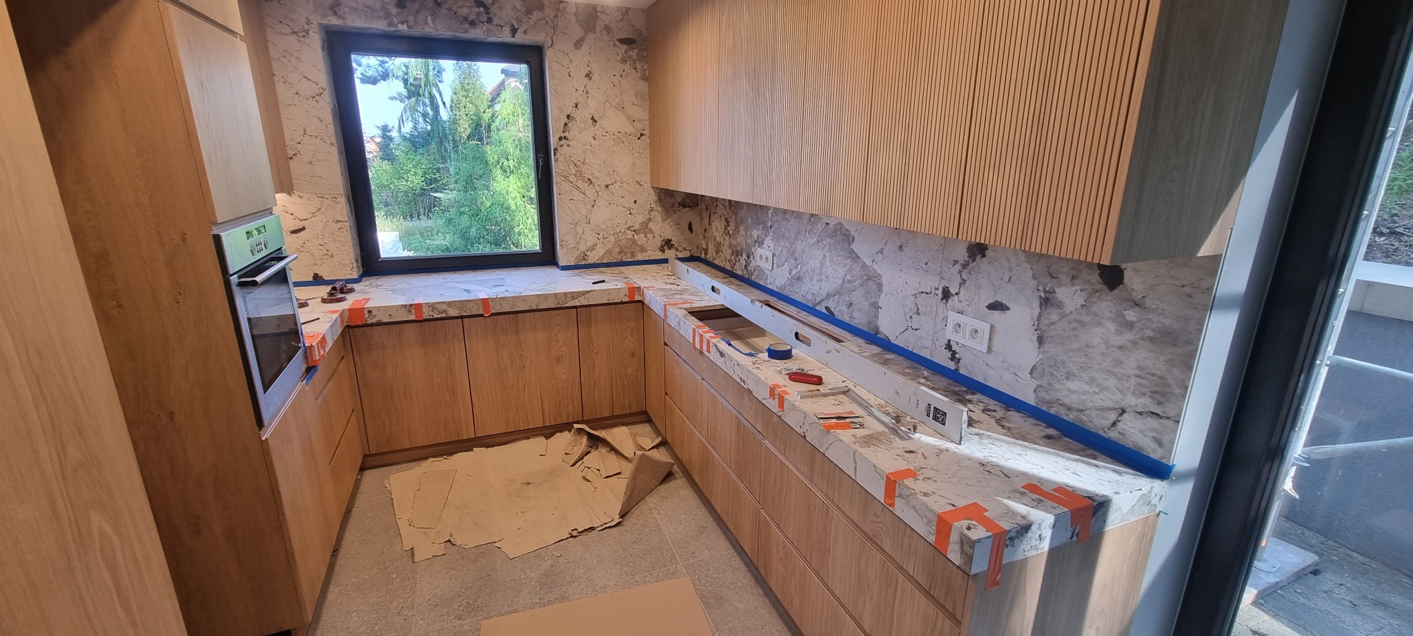 płytkie wielkoformatowe miedzy szafkami oraz na blatach w kuchni