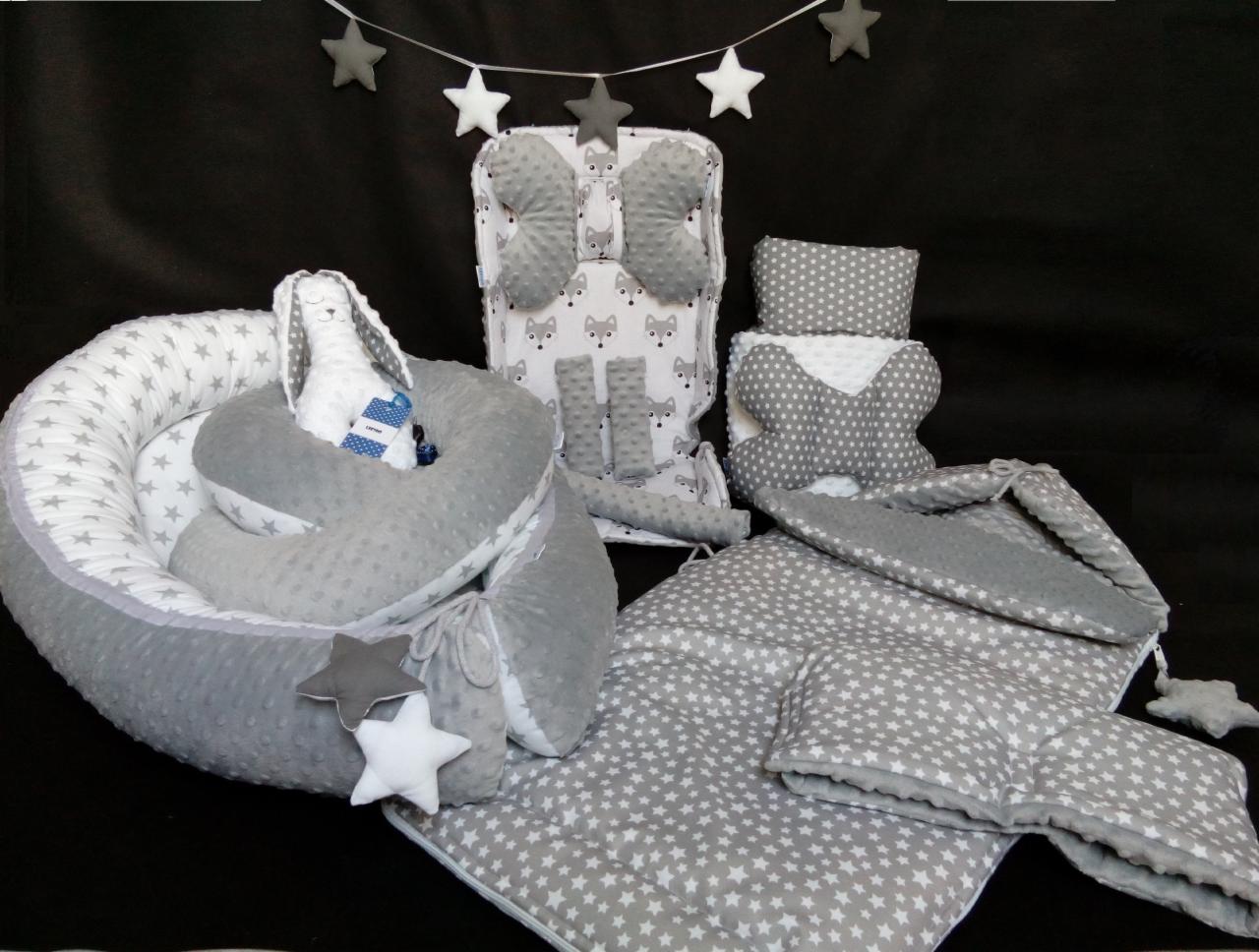 Zestaw wyprawkowy dla niemowlaka we Wrocławiu: kokon niemowlęcy z pluszowym króliczkiem, poduszka motylek, wkład do wózka z szelkami, kocyk i poduszka w gwiazdki, wszystko w odcieniach szarości...