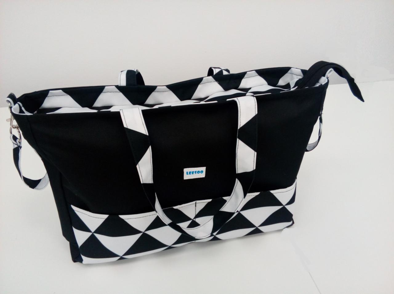 Czarno-biała torba z geometrycznym wzorem rombów, widoczne białe uchwyty i logo firmy 'LEESOO' na tle jasnego tła.
