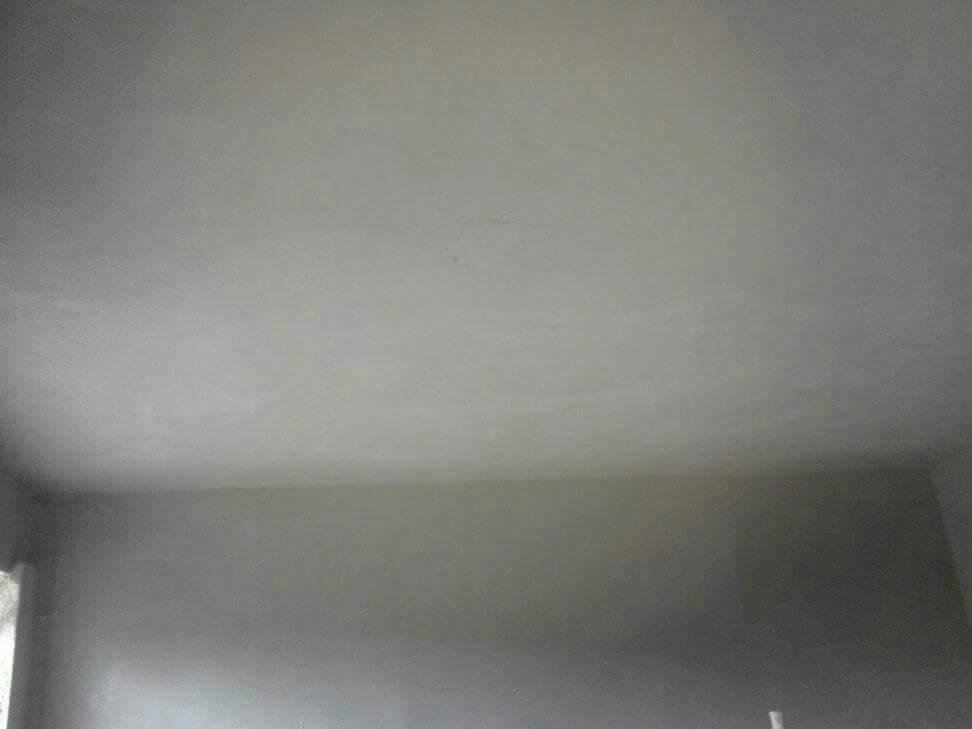 Wnętrze pokoju po nałożeniu gładzi gipsowej na ściany i sufit, widoczne niedoskonałości w wykończeniu pod światło.
