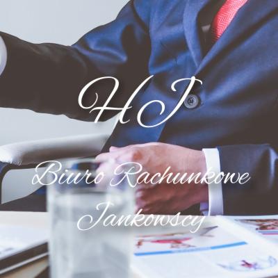 Mężczyzna w garniturze z czerwoną poszetką, siedzący przy biurku z materiałami biurowymi, na zdjęciu logo biura rachunkowego w ozdobnej czcionce.