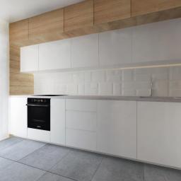 Paleta Form - Minimalistyczna kuchnia z białymi, gładkimi frontami szafek, drewnianym panelem nad szafkami wiszącymi i szarą podłogą z płytek. Podświetlenie LED umieszczone pod szafkami wiszącymi oświetla...