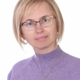 Portret kobiety w okularach z kr&oacute;tkimi blond włosami, uśmiechającej się lekko, prawdopodobnie pracującej jako specjalistka od tłumaczeń w Pieszycach.