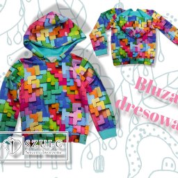 Anna Szulc - Dwie bluzy dresowe z kapturem, wykonane z kolorowego materiału w kształcie klocków Tetris na białym tle z delikatnym wzorem. Na jednej bluzie widoczne logo firmy odzieżowej 'SZULC Sercem Tworzone'.