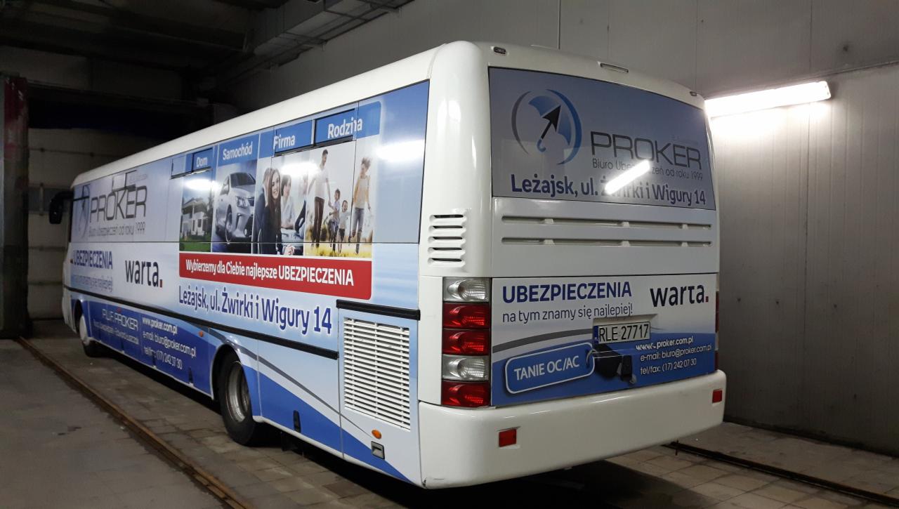 Autobus oklejony reklamą firmy ubezpieczeniowej Proker, prezentujący usługi ubezpieczeń domów, samochodów, firm i rodzin, z adresem biura w Leżajsku.
