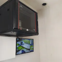 Szafa rack z monitorem podglądu z kamer w Biernej, obok biała skrzynka, widoczny fragment drabiny.