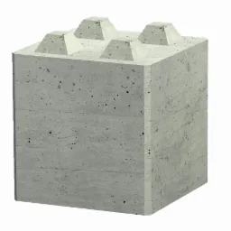 Szary betonowy blok z czterema wystającymi piramidkami na górze, przypominający duży klocek do budowania.