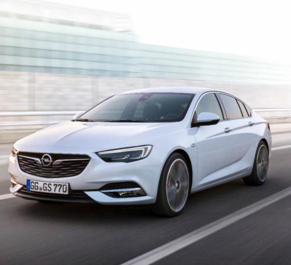 Biała Opel Insignia na drodze z rozmytym tłem, widoczne tablice rejestracyjne GG GS 770.