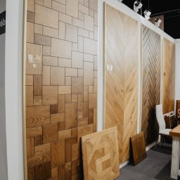 Expol 777 Sp z o.o. Tavolini Floors - Ekspozycja różnych wzorów paneli podłogowych drewnianych na stoisku targowym, widoczne panele w geometryczne wzory oraz ułożone w jodełkę.