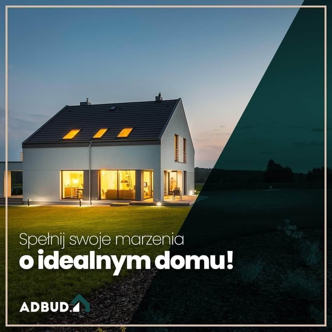 Nowoczesny, dwukondygnacyjny dom z płaskim dachem i dużymi oknami oświetlonymi od wewnątrz, sfotografowany o zmierzchu, z logo firmy w lewym dolnym rogu i sloganem reklamowym na pierwszym planie.