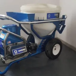 Profesjonalne urządzenie natryskowe Graco T-MAX 506 na kółkach, przeznaczone do aplikacji materiałów wykończeniowych, z widocznym zbiornikiem i panelem sterowania SmartControl.