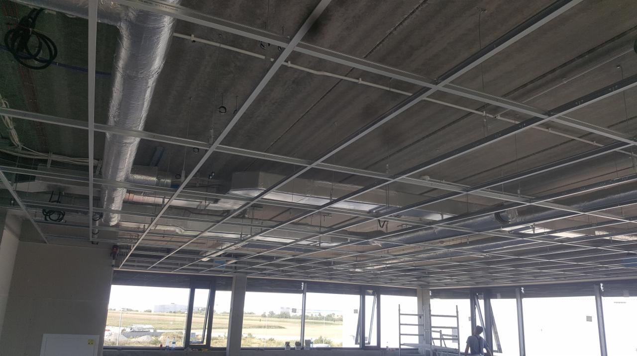 Montaż sufitu podwieszanego w nowym budynku w Cieplicach, widoczne metalowe profile i instalacje wentylacyjne.