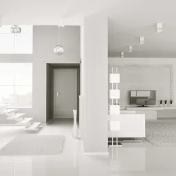 Minimalistyczne wnętrze z białymi meblami, schodami i lśniącą podłogą, oświetlone punktowymi lampami sufitowymi i lampą podłogową z ażurowym kloszem.