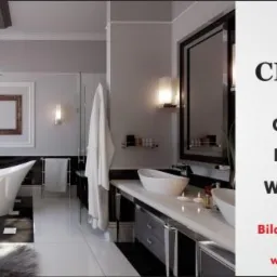 Elegancka łazienka w odcieniach szarości i bieli z wolnostojącą wanną, czarnymi akcentami i ozdobnym żyrandolem, prezentowana na tle reklamy firmy CERAMIK oferującej płytki ceramiczne i wyposażenie...